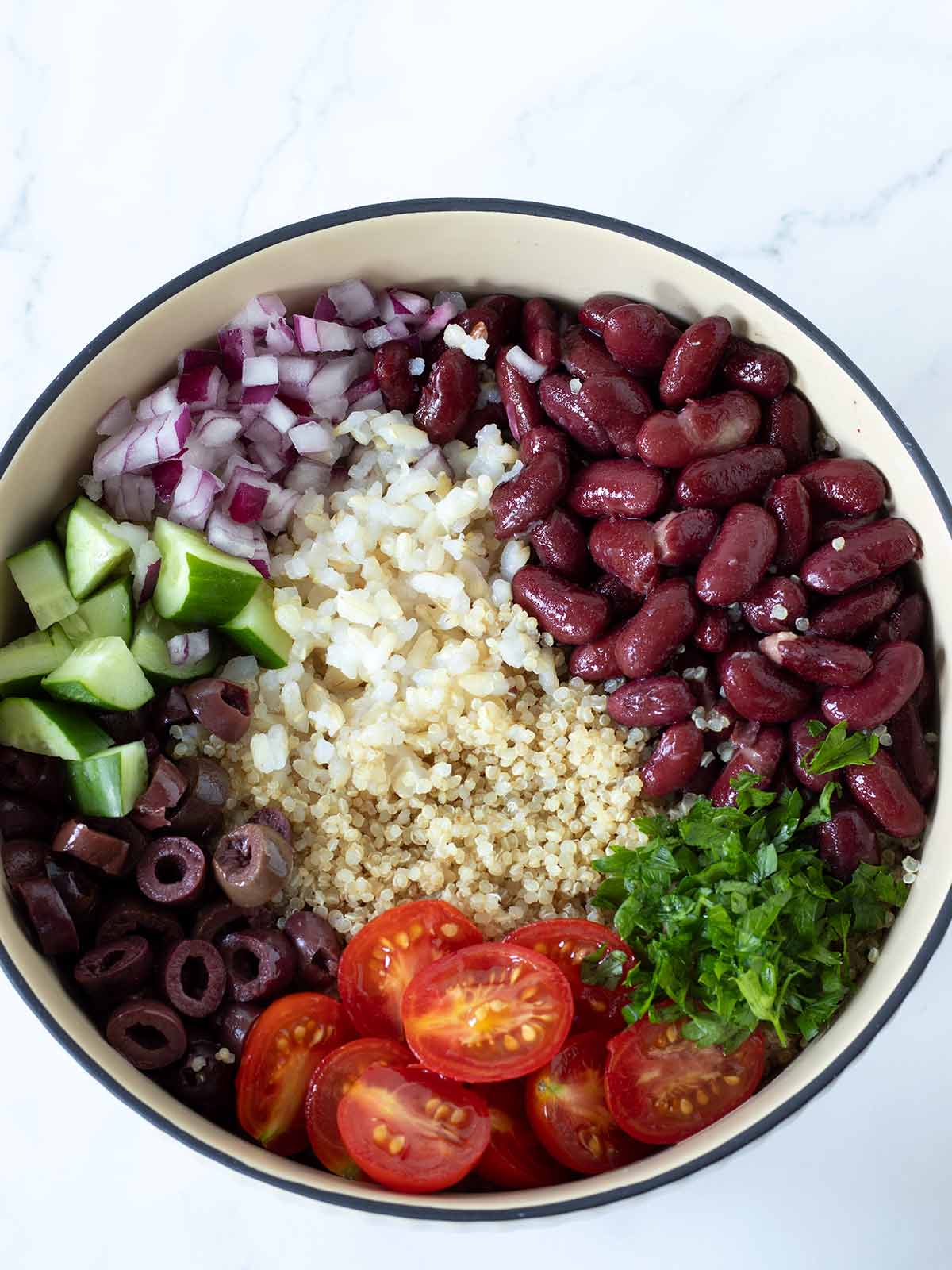 Cooked quinoa, brown rice, red kidney beans, and fresh vegetables for healthy salad.