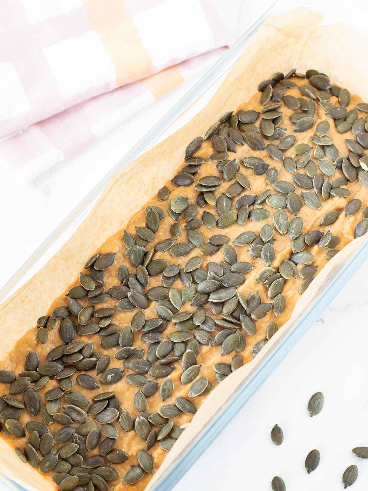 Vegan banana pumpkin bread in loaf pan prepared for baking.