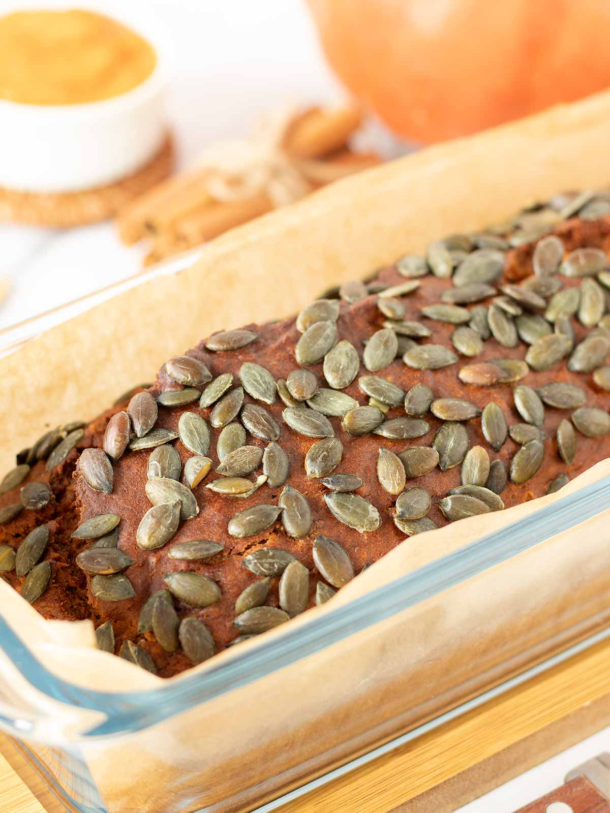 Baked vegan pumpkin banana bread topped with pumpkin seeds.