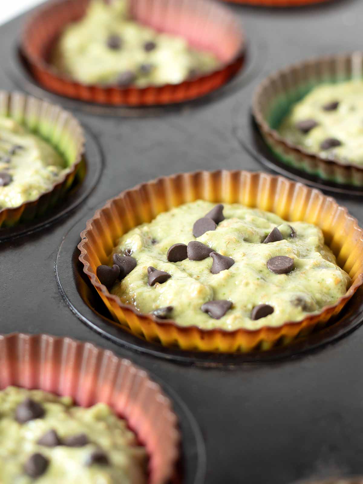 Sweet spinach muffins with banana and chocolate chips prepared for baking.
