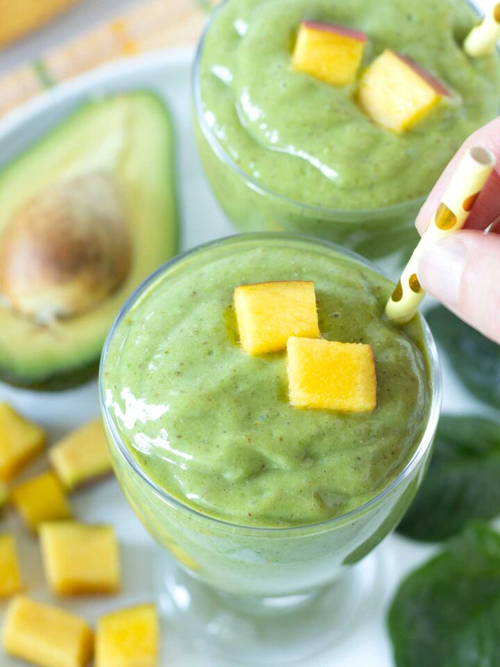 Green mango avocado smoothie with banana and spinach.
