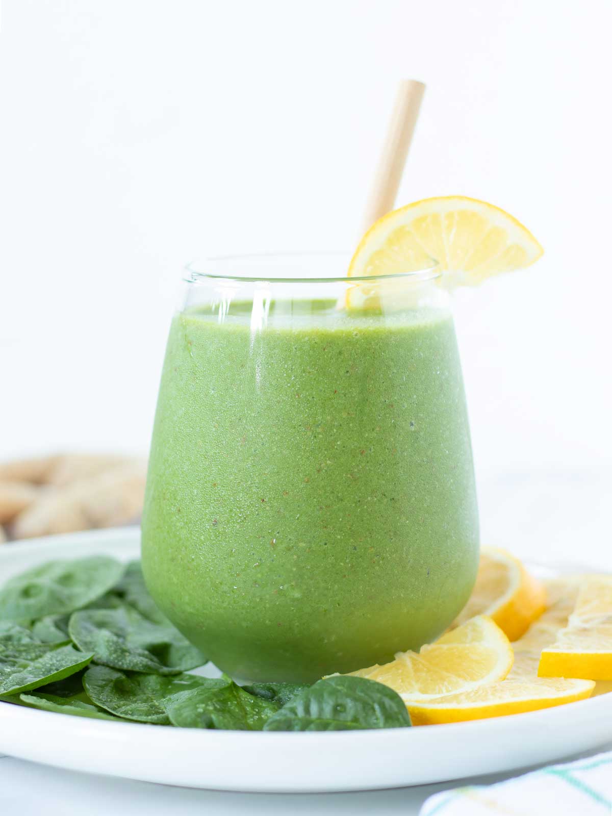 Green spinach ginger lemon smoothie with banana and almond milk.