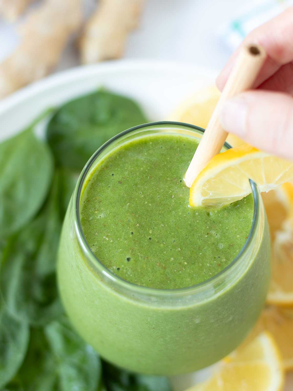 Vegan green spinach ginger smoothie with lemon and banana.