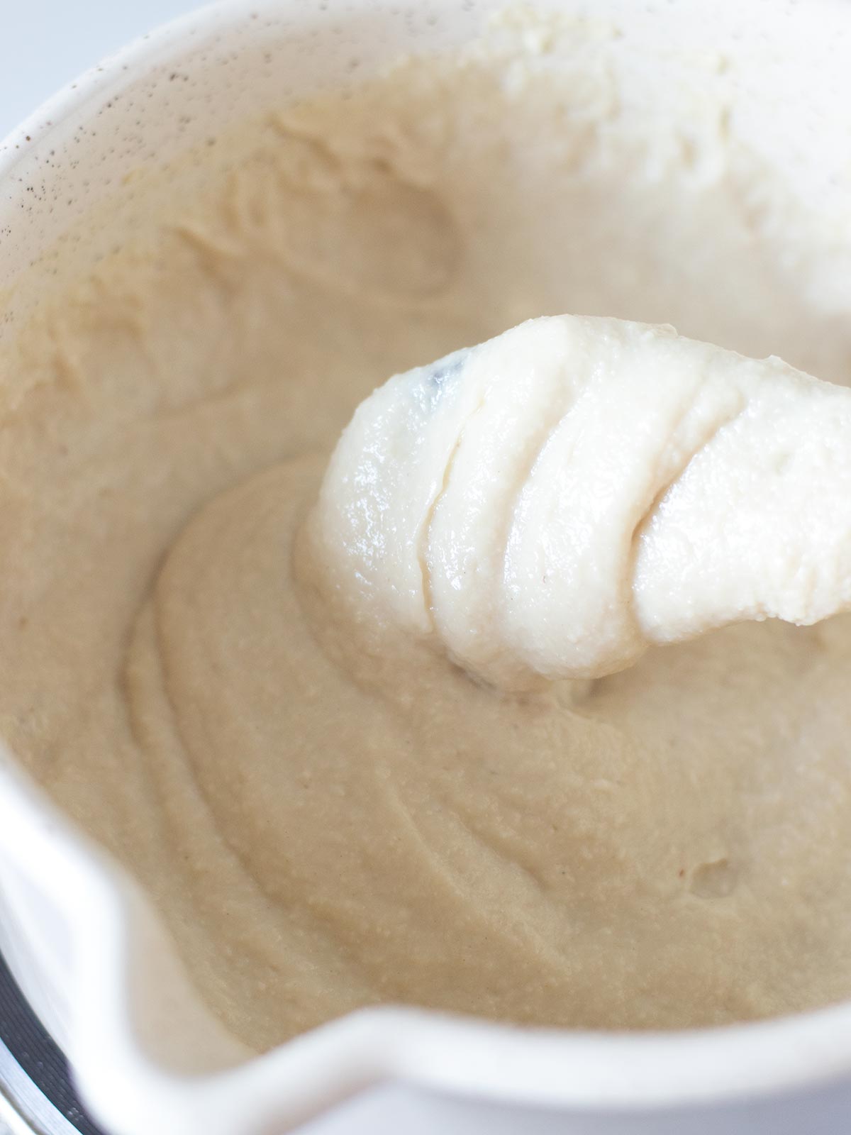 Creamy homemade vegan mozzarella cheese in saucepan.