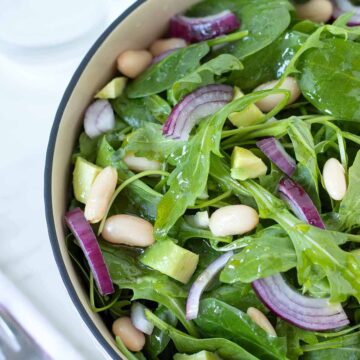 Spinach arugula salad with avocado and cannellini beans.