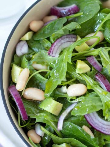 Spinach arugula salad with avocado and cannellini beans.