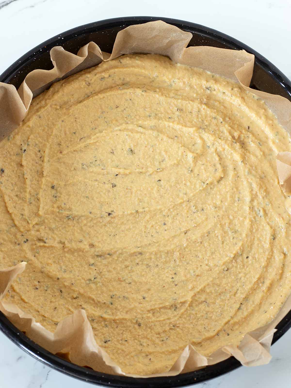 Chickpea flour pizza crust in a baking pan.