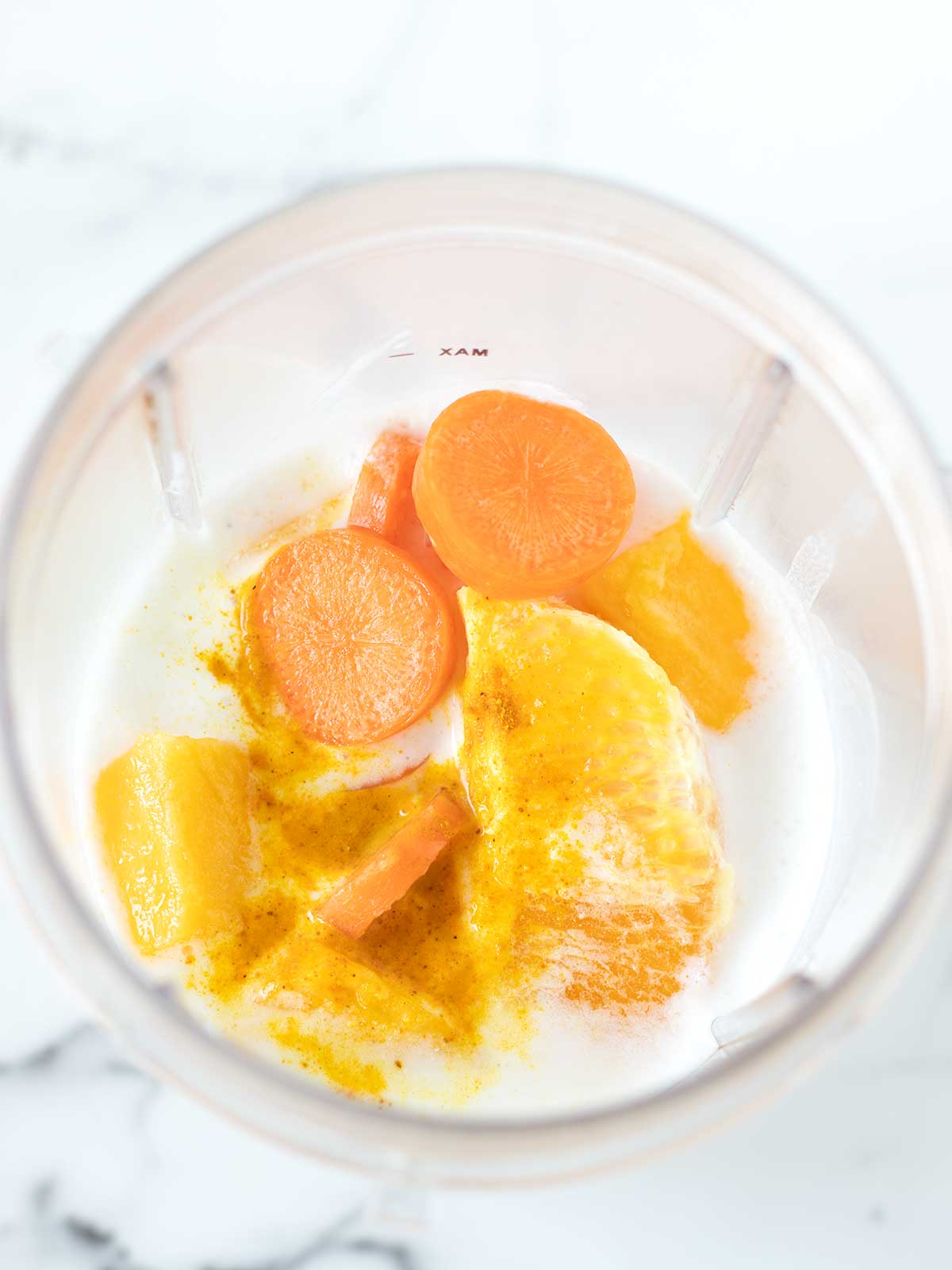 Mango orange carrot coconut milk smoothie ingredients.