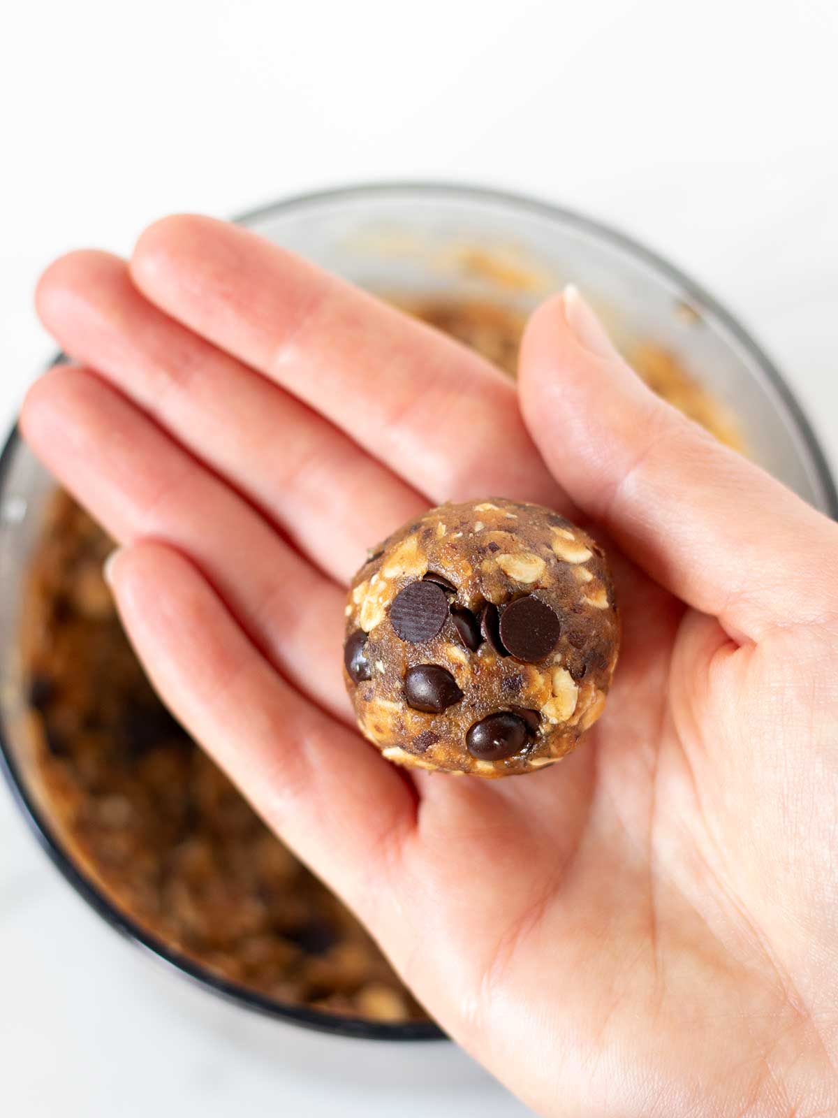 Rolling vegan oat peanut butter date energy ball.