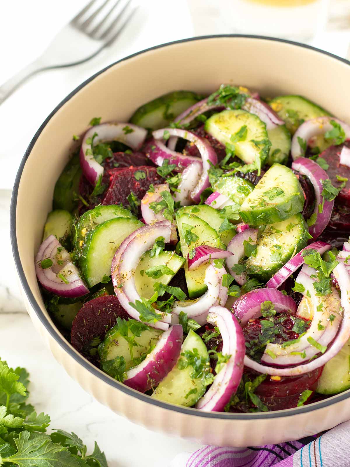 Beetroot cucumber salad with red onion and parsley.