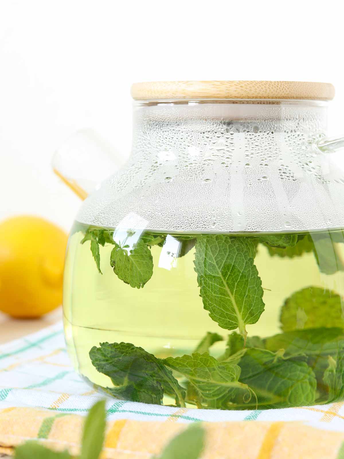 Fresh mint leaves with hot water in a teapot.