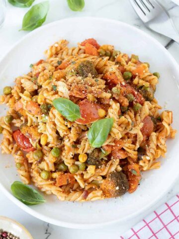 Vegan pasta primavera made with vegetables and red sauce.