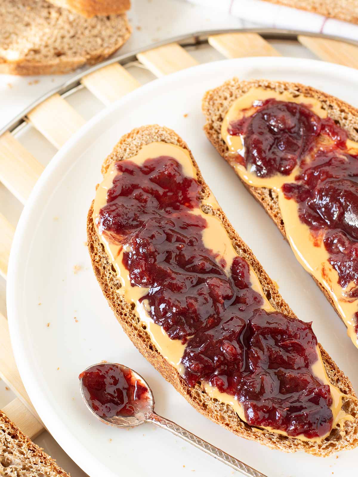 Sliced rustic whole wheat bread with peanut butter and jam.