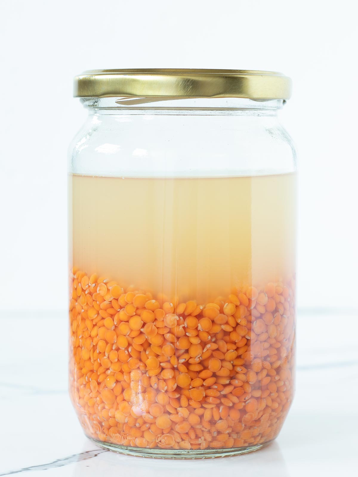 Soaking red lentils for savory breakfast pancakes.