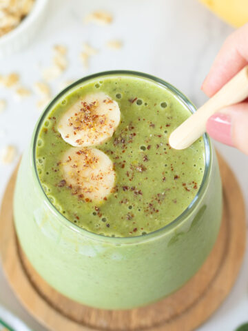 Green breakfast smoothie with oats, spinach, banana, and peanut butter.