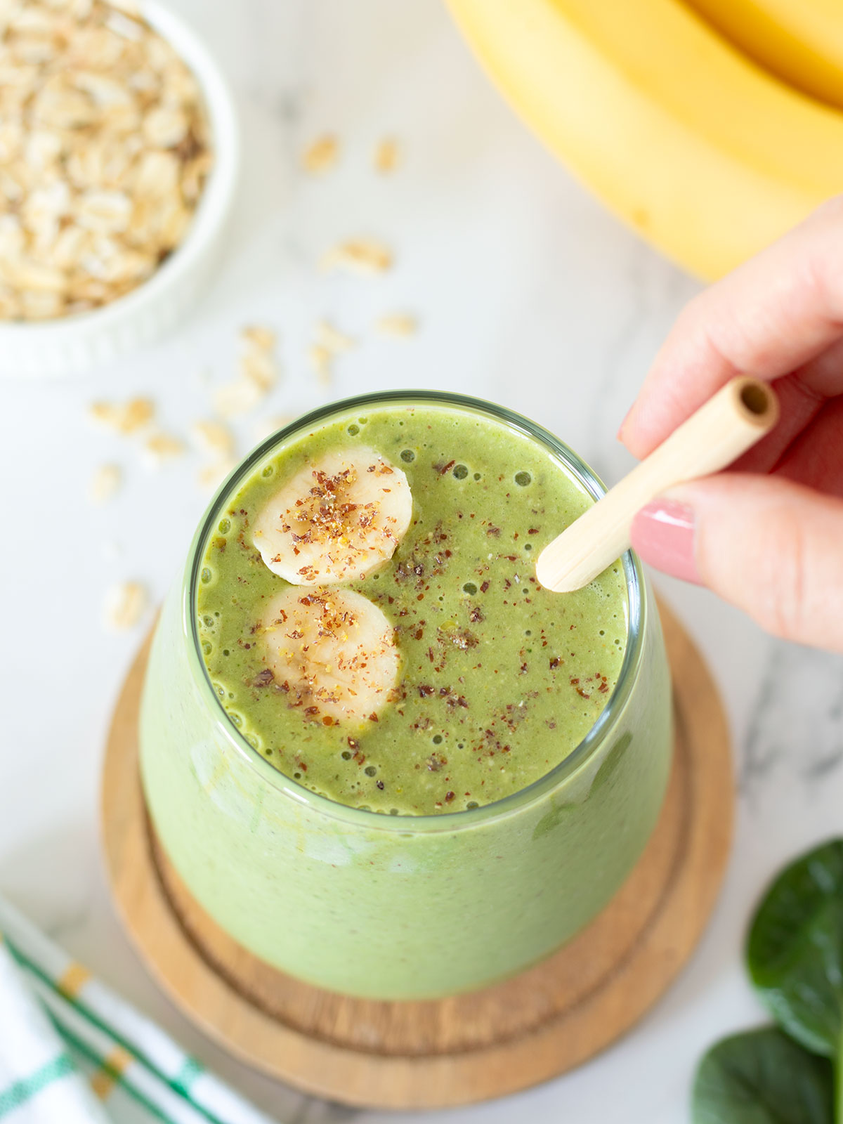 Green breakfast smoothie with oats, spinach, banana, and peanut butter.