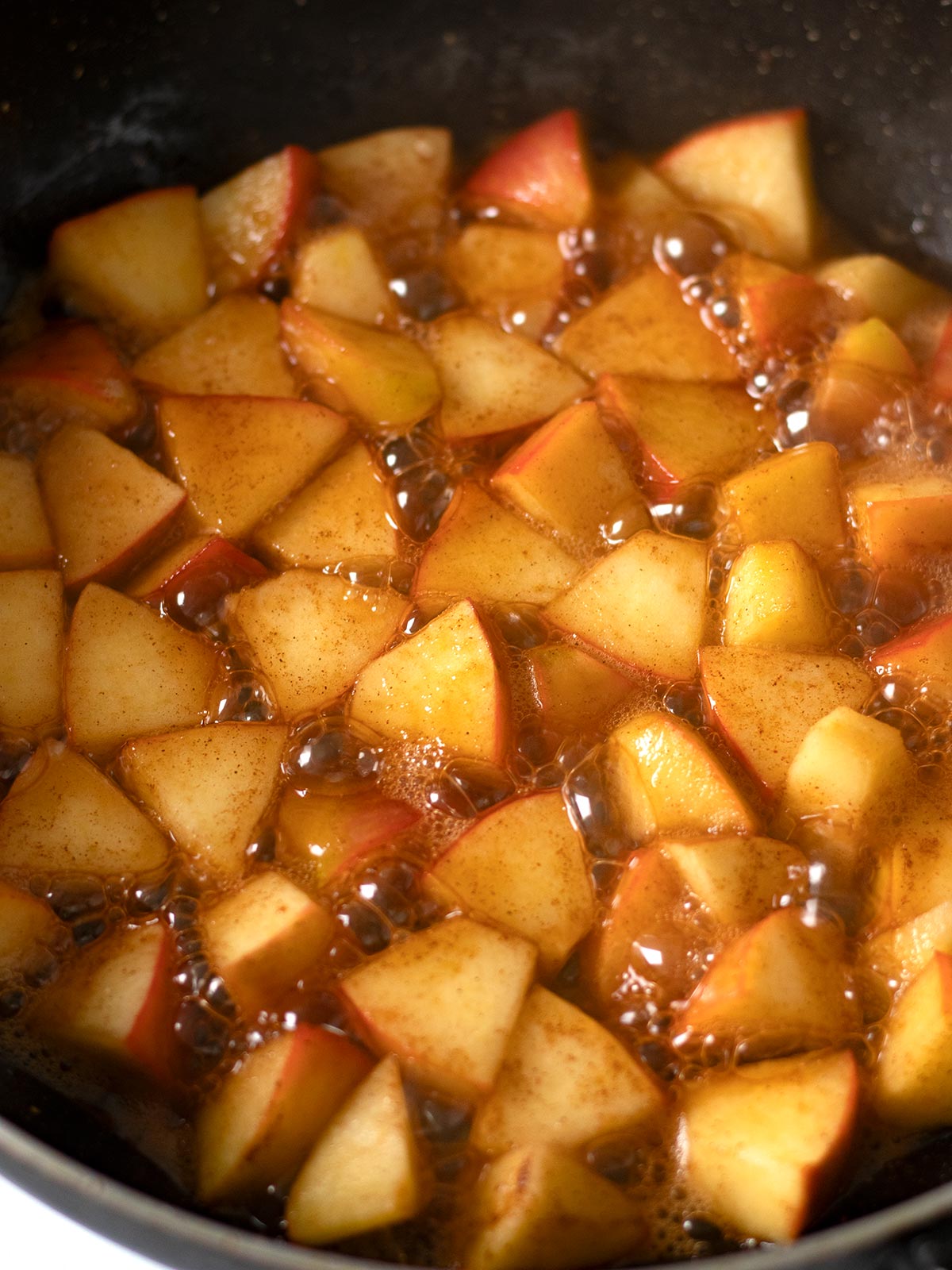 Cooking caramelized apples with brown sugar and cinnamon.