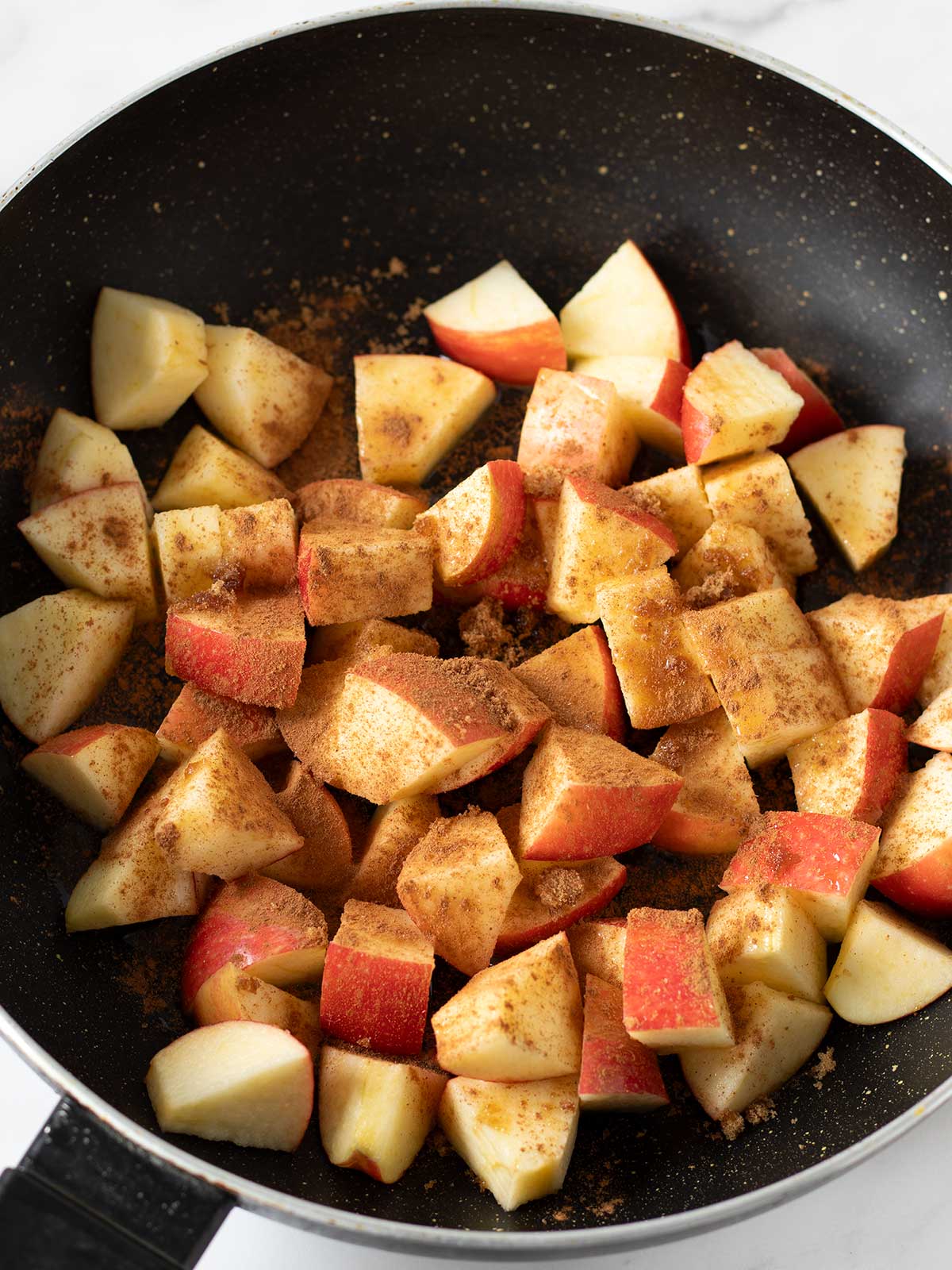 Diced apples with brown sugar, cinnamon and lemon juice prepared for cooking.