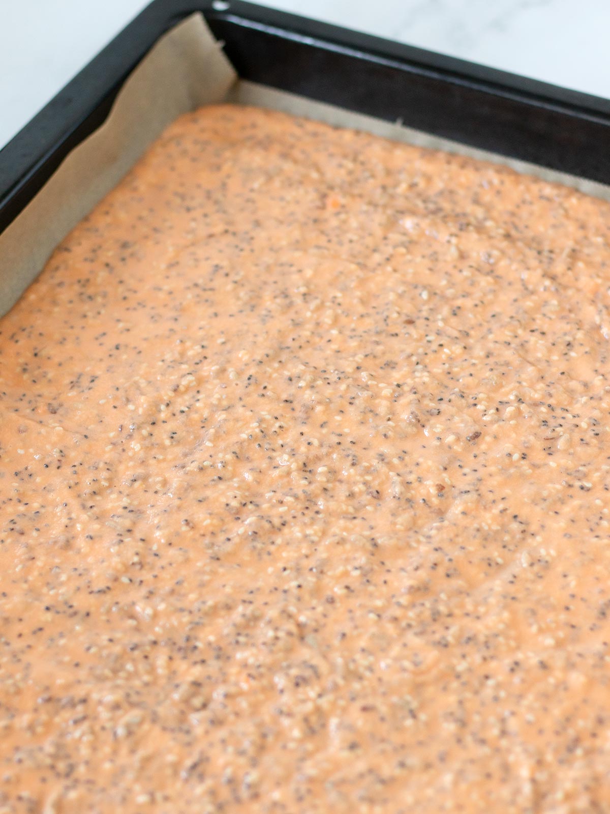 Red lentil crackers batter in a baking sheet.