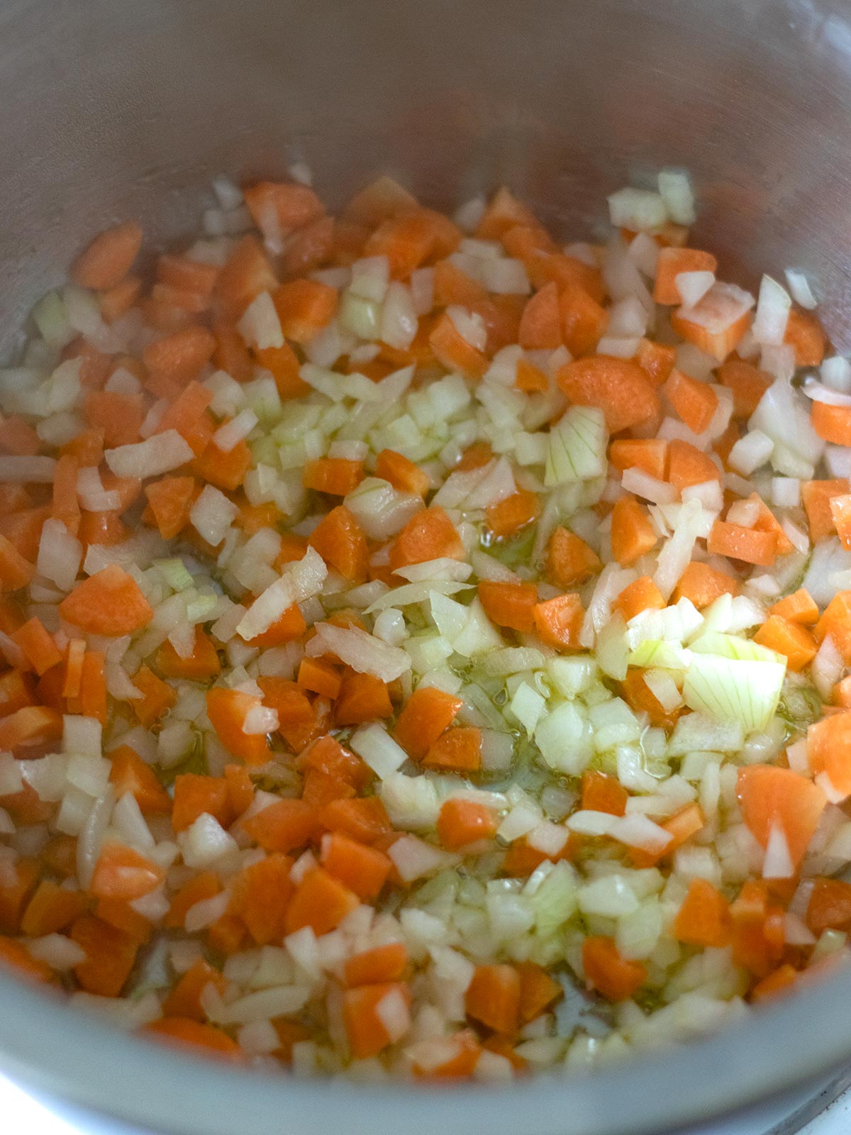 Cooking onion and carrot for red lentil pasta.