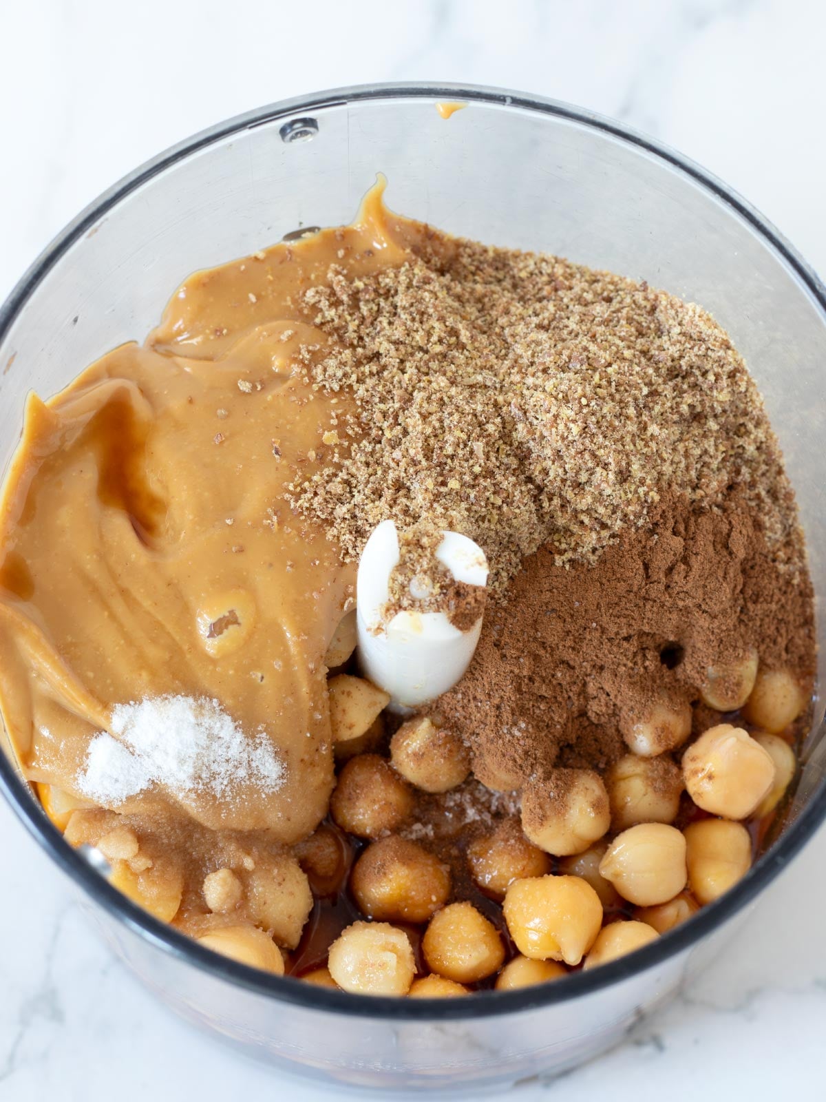Ingredients for vegan chickpea peanut butter cookies in a food processor.